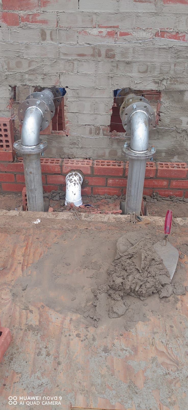 Steel pipework passing through a new brick wall