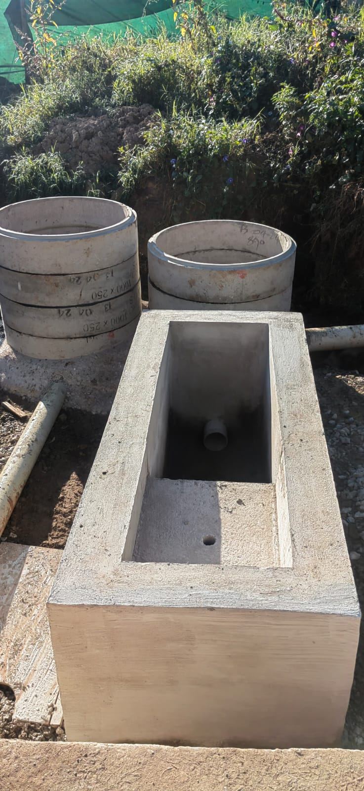 Precast concrete chamber beside manhole rings