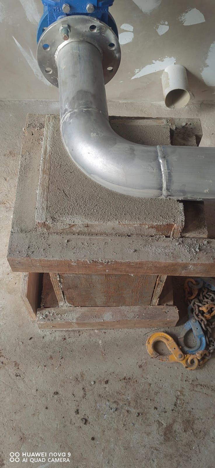 Steel pipe bend on a concrete plinth